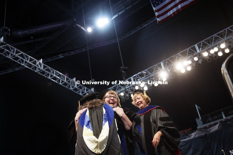 Erica Rogers hugs Professor Deborah Minter after Rogers received her doctoral hood. Students earning graduate and professional degrees received their diplomas Friday afternoon in Lincoln's Pinnacle Bank Arena. Undergraduate commencement is Saturday