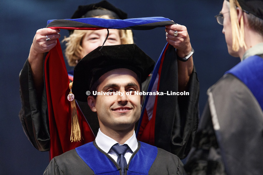Mohsen Zahiri has his doctoral hood is placed over his head. His thesis involved computer vision in surgical robotics. Students earning graduate and professional degrees received their diplomas Friday afternoon in Lincoln's Pinnacle Bank Arena.