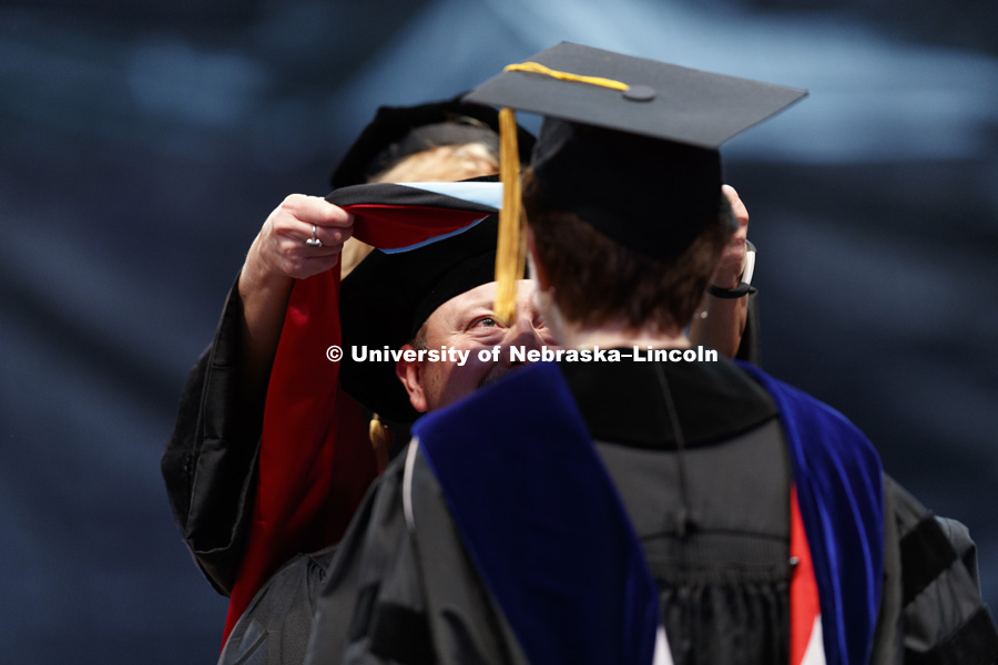 Travis Miller has his doctoral hood lowered over his head during Friday's ceremony after receiving his EDD degree. Students earning graduate and professional degrees received their diplomas Friday afternoon in Lincoln's Pinnacle Bank Arena. Undergraduate