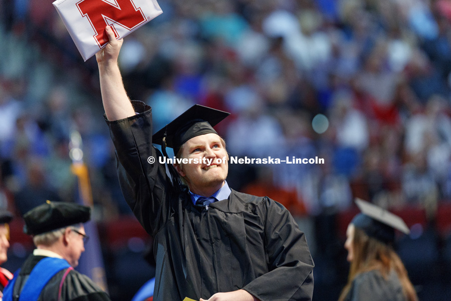 Joseph Bennier shows off his College of Agricultural Sciences and Natural Resources diploma to his family and friends in the arena. Students received their undergraduate diplomas Saturday morning in Lincoln's Pinnacle Bank Arena. 2452 degrees were awarded