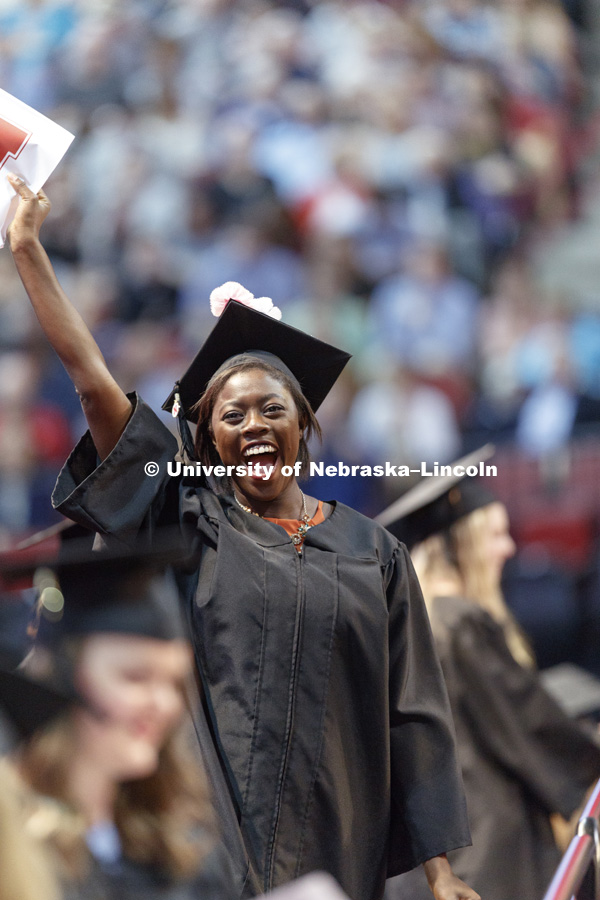 Temitope Banwo shows off her College of Education and Human Sciences diploma to family and friends in the arena. Students received their undergraduate diplomas Saturday morning in Lincoln's Pinnacle Bank Arena. 2452 degrees were awarded Saturday morning.