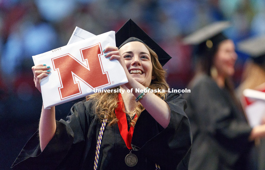 Morgan Brummels shows off her College of Education and Human Sciences diploma to family and friends in the arena. Students received their undergraduate diplomas Saturday morning in Lincoln's Pinnacle Bank Arena. 2452 degrees were awarded Saturday morning.