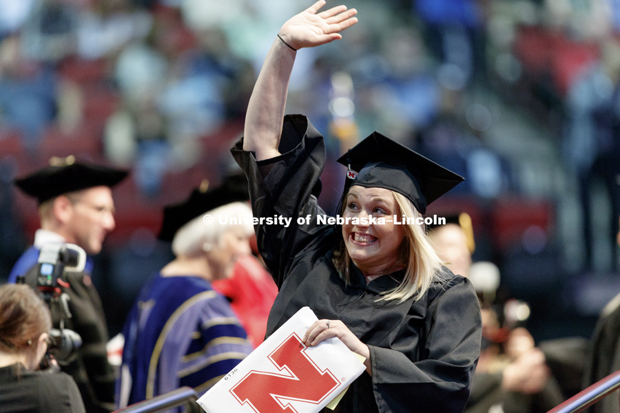 College of Education and Human Sciences graduate Lindsay Henkenius waves to family and friends in the arena. Students received their undergraduate diplomas Saturday morning in Lincoln's Pinnacle Bank Arena. 2452 degrees were awarded Saturday morning. May