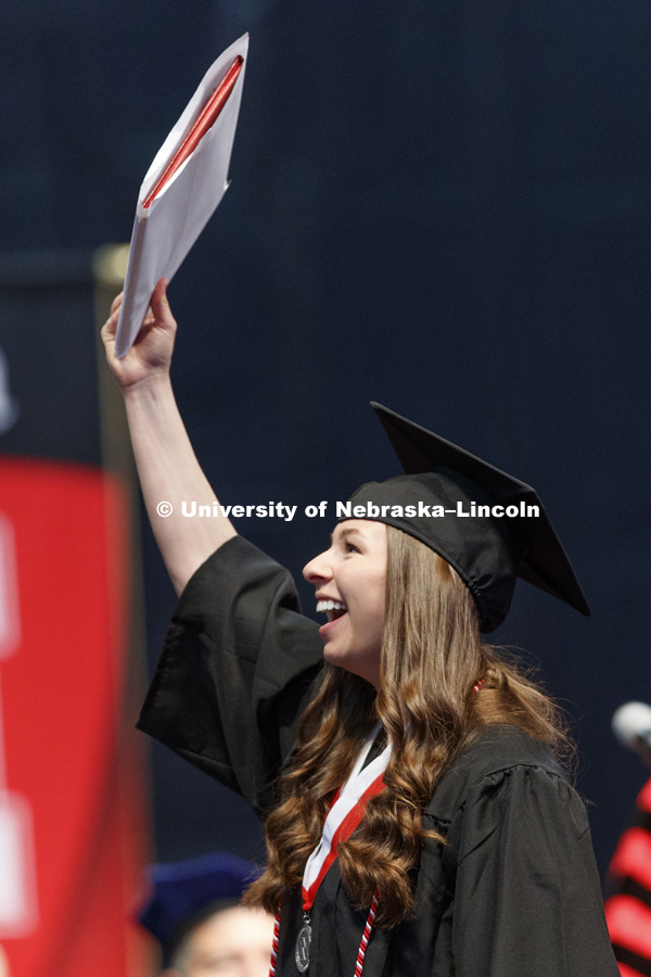 Alisa Michaela Rogonsienski Pape shows off her College of Education and Human Sciences diploma to family and friends in the arena. Students received their undergraduate diplomas Saturday morning in Lincoln's Pinnacle Bank Arena. 2452 degrees were awarded