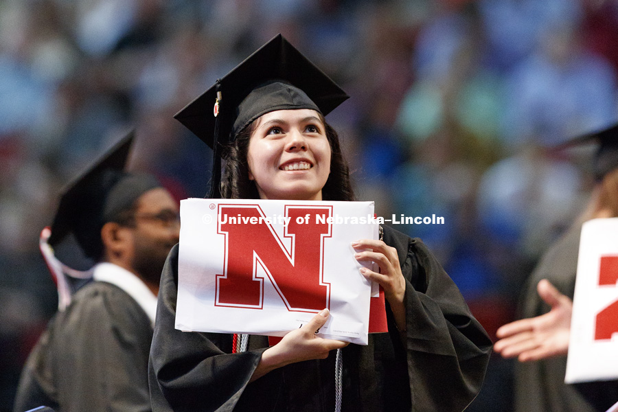 Zully Alejandra Perez Sierra shows off her College of Engineering diploma to family and friends in the arena. Students received their undergraduate diplomas Saturday morning in Lincoln's Pinnacle Bank Arena. 2452 degrees were awarded Saturday morning. May