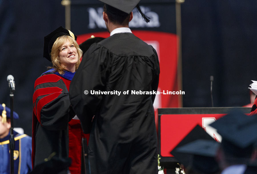College of Business Interim Dean Kathy Farrell awards diplomas to business graduates. Students received their undergraduate diplomas Saturday morning in Lincoln's Pinnacle Bank Arena. 2452 degrees were awarded Saturday morning. May 6, 2017. Photo by Craig