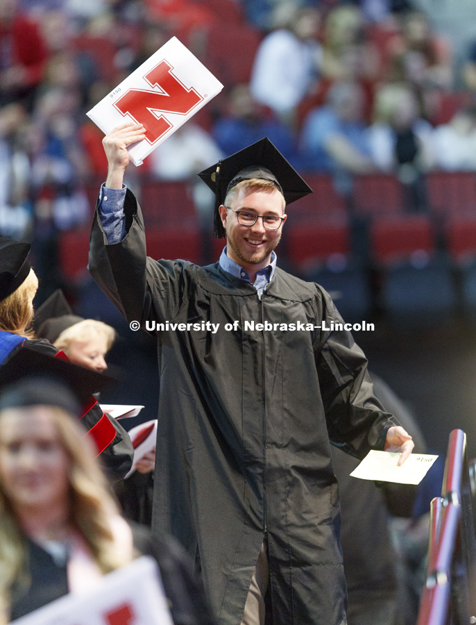 Reid Hooper shows off his College Business diploma to family and friends in the arena. Students received their undergraduate diplomas Saturday morning in Lincoln's Pinnacle Bank Arena. 2452 degrees were awarded Saturday morning. May 6, 2017. Photo by