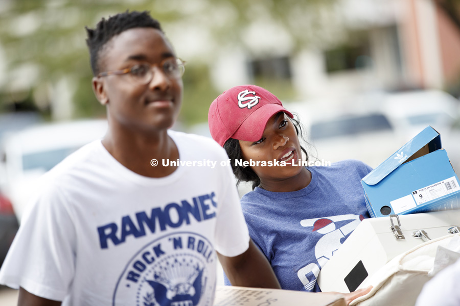 Jovann Harrington carries an arm-load of belongings toward Schramm residence hall. Sorority Rush move-in for residence halls. Housing. August 13, 2017. Photo by Craig Chandler / University Communication.