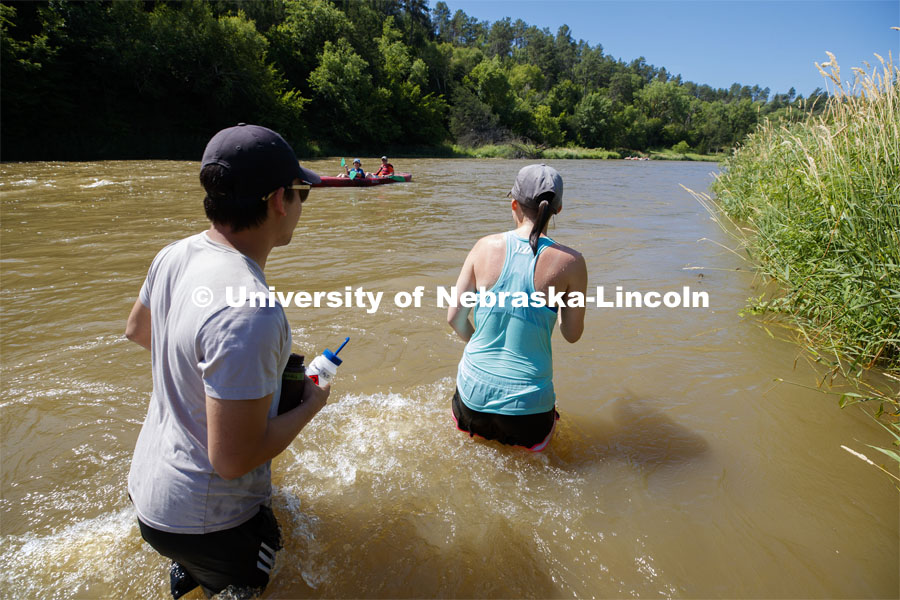 Kayla Vondracek and Matthew Chen exchange greetings with kayakers on the Niobrara. Jessica Corman, assistant professor in the School of Natural Resources, UCARE research group researching algae in the Niobrara River. Fort Niobrara National Wildlife Refuge. July 12, 2019. Photo by Craig Chandler / University Communication.