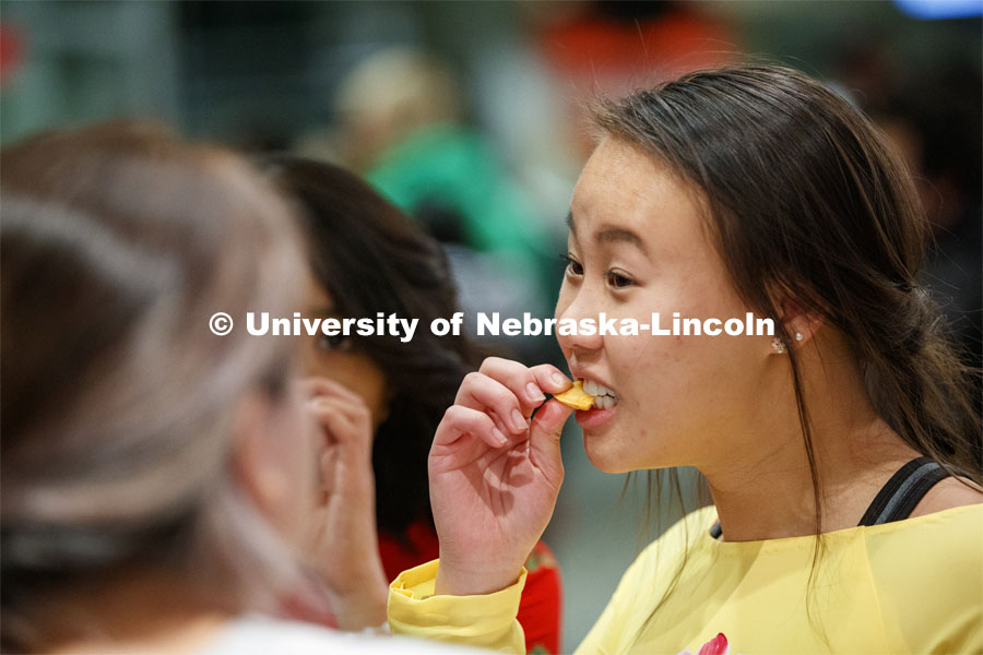Katelyn Le tries one of the many food items. She is wearing an ao dai, a traditional Vietnamese gown often work at Vietnamese New Year celebrations. Global Huskers Festival, a multicultural festival provides attendees the chance to explore the world through informational booths that will have food, cultural décor, art, and more, each hosted by UNL students from those culture. November 19, 2019 Photo by Craig Chandler / University Communication.