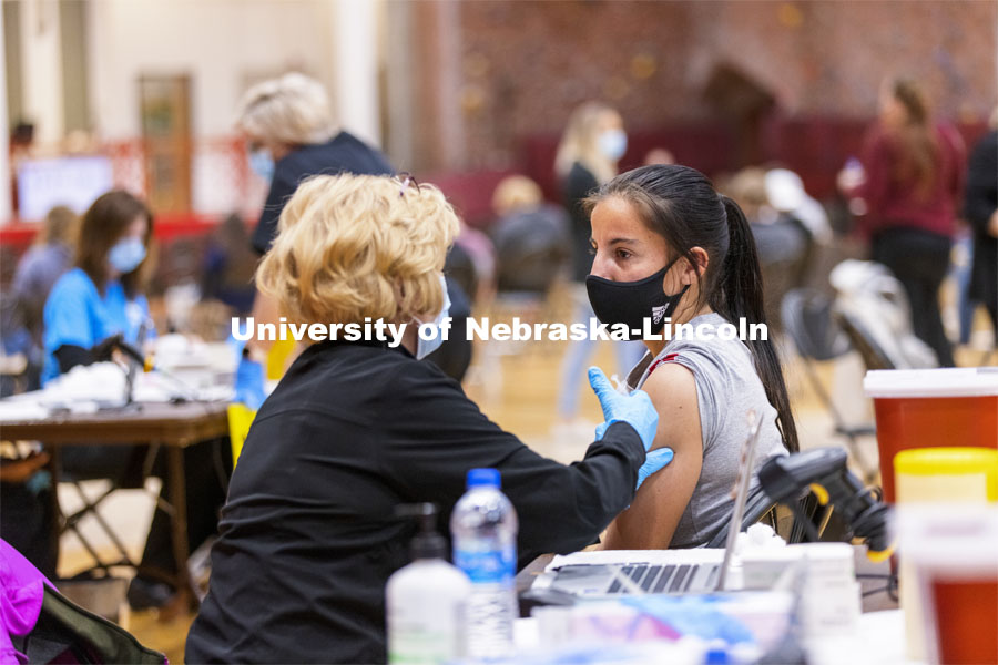 Isabel Adrover receives her first dose of vaccine during a COVID-19 vaccination clinic April 20 at the Coliseum. Vaccine clinic in the Coliseum with a free food and goodies tent outside. April 20, 2021. Photo by Craig Chandler / University Communication.