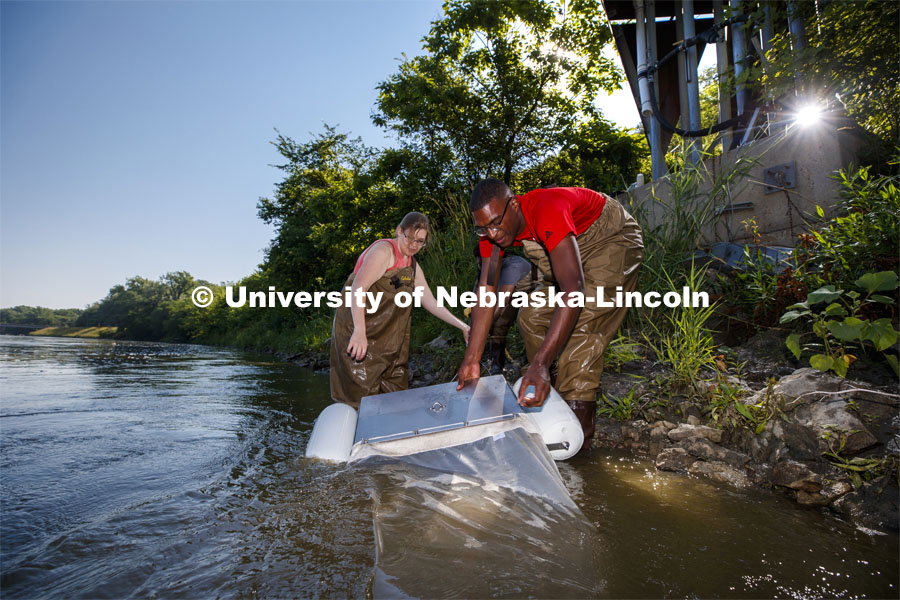 Meredith Sutton, graduate student in environmental engineering, McNair scholar Seth Caines, and summer research scholar Moriah Brown from Howard University retrieve a floating sieve to sample water from the Elkhorn River. They are working with Professor Shannon Bartlet-Hunt researching textiles as a source of microplastic fibers to Nebraska streams. July 2, 2021. Photo by Craig Chandler / University Communication.