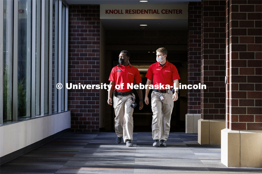 UNLPD Community Service Officers Komlan Akakpo and Trevor Caldwell walk the hallway between Knoll and University Suites. The CSOs are wearing more casual uniforms in 2022. January 7, 2022. Photo by Craig Chandler / University Communication.