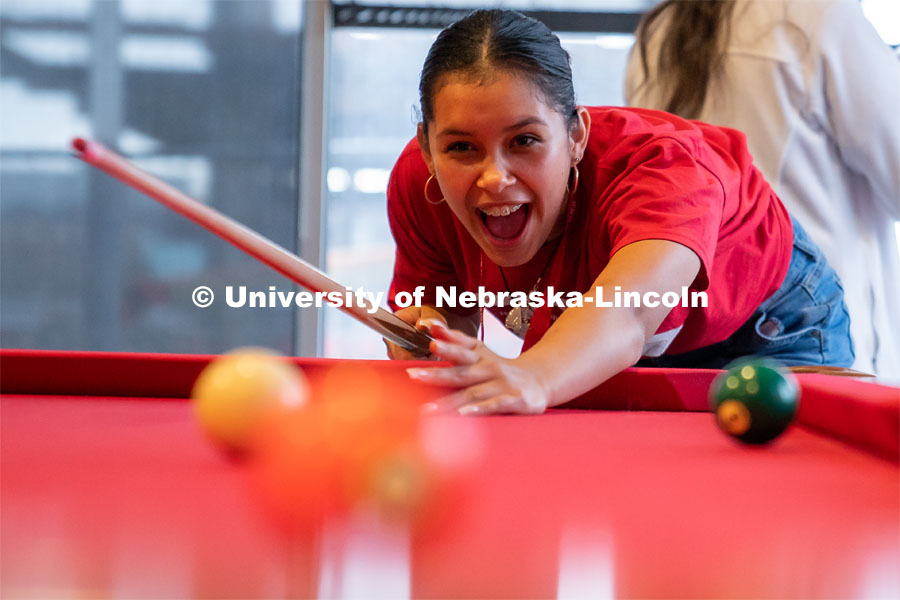 An Attendee reacts after hitting the ball during a game of pool at the Nebraska College Preparatory Academy’s Science Camp inside Abel Hall. NCPA, a program for academically talented, first-generation, income eligible students to help prepare them for college and their future careers. June 9, 2022. Photo by Jordan Opp for University Communication.