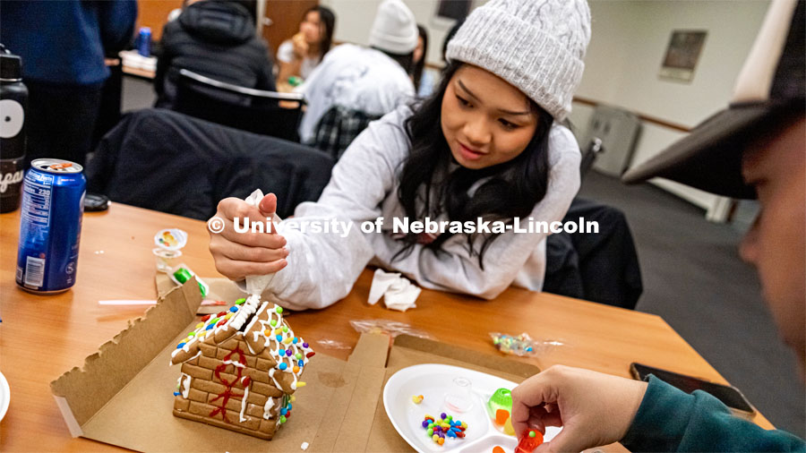 Katie Tran, junior studying Nutrition Sciences, adding her finishing touches to her gingerbread house. Students celebrate the upcoming holidays and the semester coming to close by making gingerbread houses, playing games with the opportunity to win prizes, and enjoying holiday refreshments. Students were encouraged to socialize with each other and share any holiday traditions they partake in. December 8, 2022. Photo by Jonah Tran / University Communication.