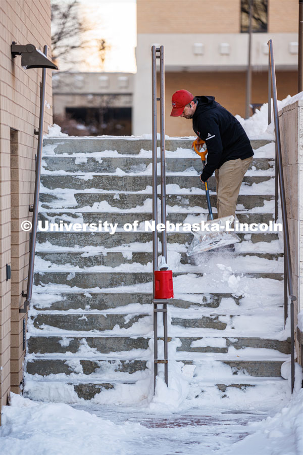 Ron Natale, Facilities Services Manager with the Lied Center for Performing Arts, clears the steps alongside the center Friday morning. A snowy Friday on city campus. February 17, 2023. Photo by Craig Chandler / University Communication.