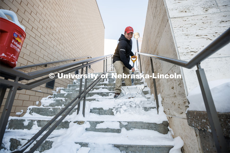 Ron Natale, Facilities Services Manager with the Lied Center for Performing Arts, clears the steps alongside the center Friday morning. A snowy Friday on city campus. February 17, 2023. Photo by Craig Chandler / University Communication.