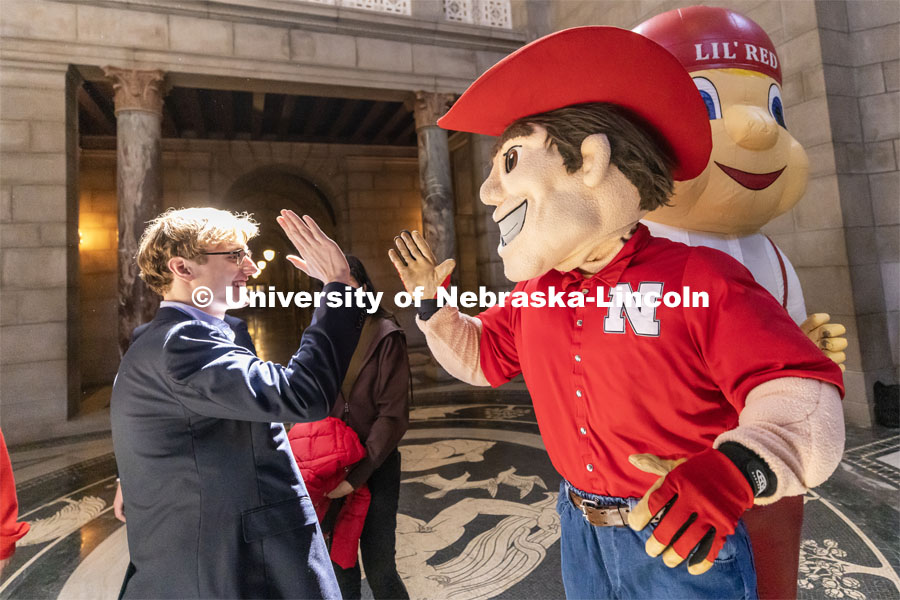 ASUN incoming president Paul Pechous high fives Herbie at the I Love NU advocacy event at the Nebraska State Capitol. April 5, 2023. Photo by Craig Chandler / University Communication.