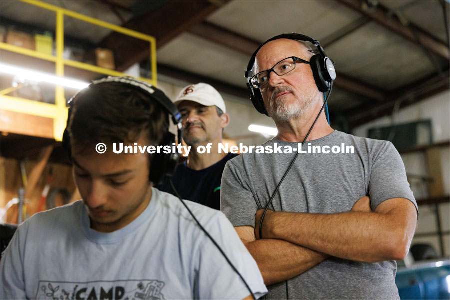 Richard Endacott watches the filming on a remote monitor over the shoulder of UNL student and script supervisor Charlie Major. Filming of the movie using UNL students as the production crew. Endacott earned multiple awards for his screenplay, "Turn Over." Story about keeping the family farm operating in the modern era as two brothers come together via restoring an old tractor to help fund their operations. August 9, 2023. Photo by Craig Chandler / University Communication.