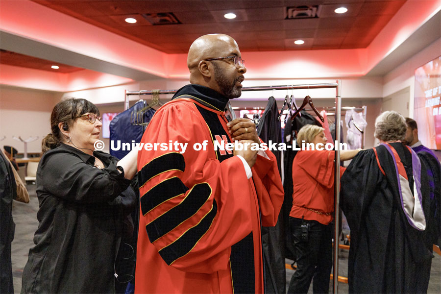 Annette Wetzel, Executive Director of Special Events and Protocol, adjusts the hood for Chancellor Rodney Bennett as he wears the UNL regalia for the first time Saturday. The University of Nebraska–Lincoln is conferring 588 degrees during the combined graduate and undergraduate commencement ceremony at Pinnacle Bank Arena. August 12, 2023. Photo by Craig Chandler/ University Communication.