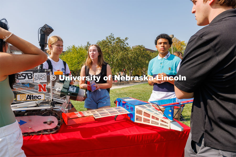 Emily Ciesielski, left, Jillian Weland, and Wilson Overfield all freshman from Omaha, look over the College of Engineering’s Aerospace Club table. Club Fair on city campus. Club Fair is a part of Big Red Welcome. August 29, 2023. Photo by Craig Chandler/ University Communication.