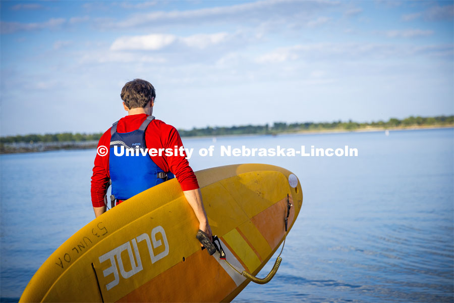 Paddleboarders carry their boards into Branched Oak Lake. About Lincoln - Paddleboarding at Branched Oak Lake with Campus Rec. September 13, 2023. Photo by Kristen Labadie / University Communication.