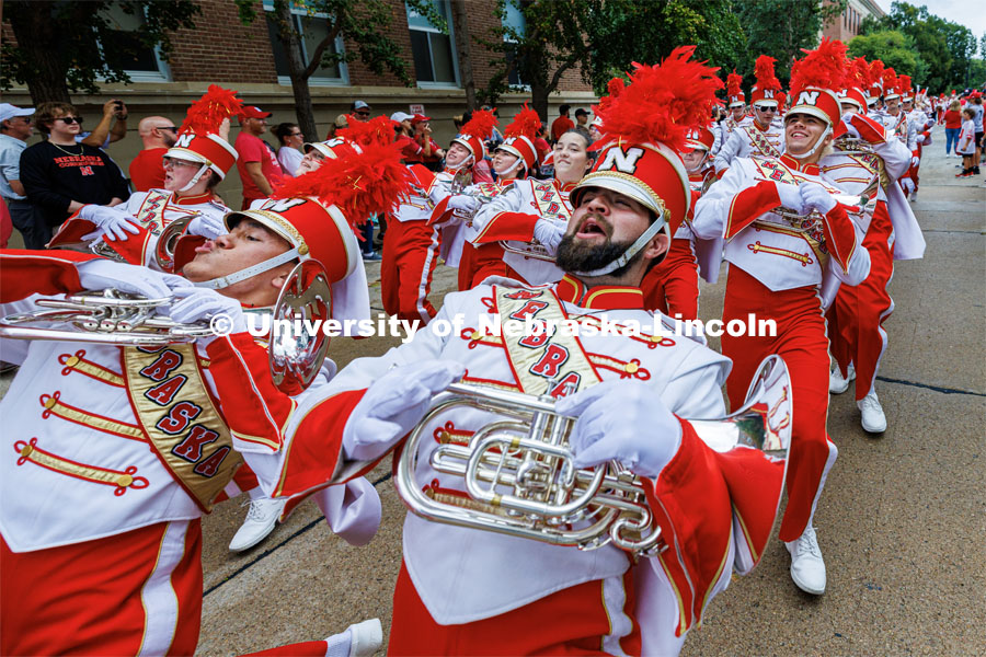 The horn sections limbos down the street as the band marches to the stadium. Nebraska football vs. Louisiana Tech. August 23, 2023. Photo by Craig Chandler/ University Communication.