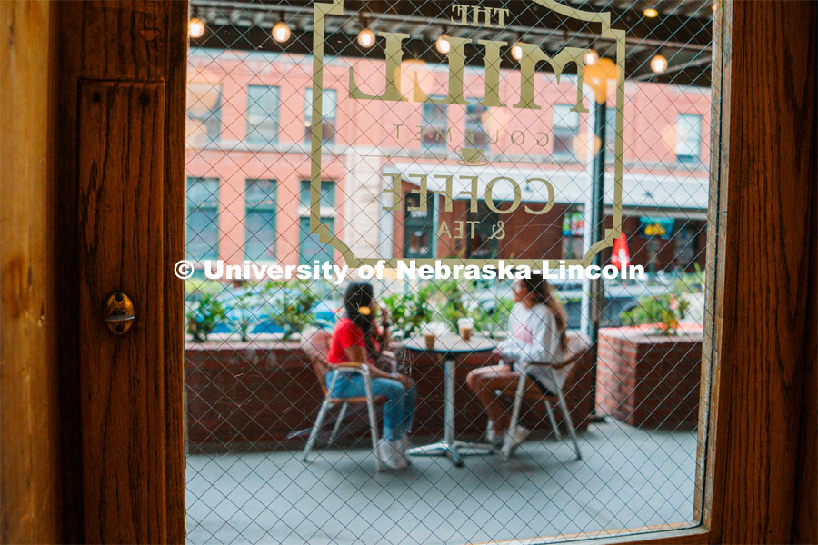 Grace Patel (right) and Isela Tercero on the patio of The Mill in the Haymarket. About Lincoln at Coffee Shops in the Haymarket. October 17, 2023. Photo by Matthew Strasburger / University Communication.