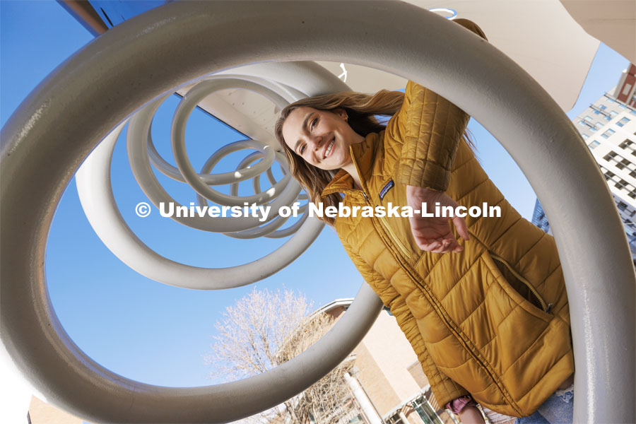 Nonie Mitchell, a senior in secondary education, attends UNL with a scholarship from The Nebraska Promise program. The program covers undergraduate tuition at the University of Nebraska's four campuses (UNK, UNL, UNMC and UNO) and its two-year technical college (NCTA). Mitchell is posing by the Torn Notebook Sculpture on City Campus. November 27, 2023. Photo by Craig Chandler / University Communication and Marketing.