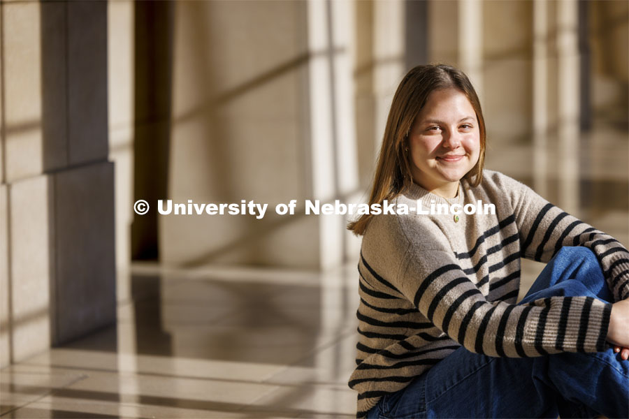 Francie Heeren, junior in political science and ethnic studies, attends UNL with a scholarship from The Nebraska Promise program. The program covers undergraduate tuition at the University of Nebraska's four campuses (UNK, UNL, UNMC and UNO) and its two-year technical college (NCTA). Heeren is photographed in different areas of the State Capitol. December 13, 2023. Photo by Craig Chandler / University Communication and Marketing.