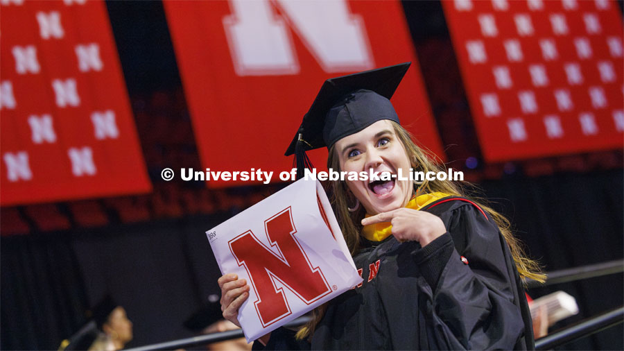 Emily Rowen gestures to family and friends after she received her master’s degree in natural resource sciences. Graduate Commencement at Pinnacle Bank Arena. December 15, 2023. Photo by Craig Chandler / University Communication and Marketing.