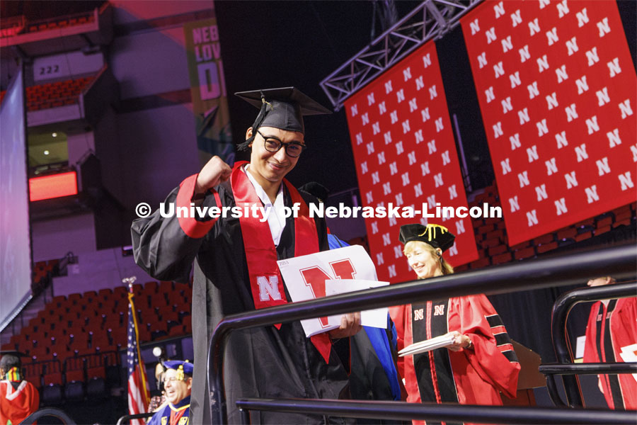 Zoyace Shrestha waves to family and friends after receiving his Engineering degree. Winter undergraduate commencement in Pinnacle Bank Arena. December 16, 2023. Photo by Craig Chandler / University Communication and Marketing.