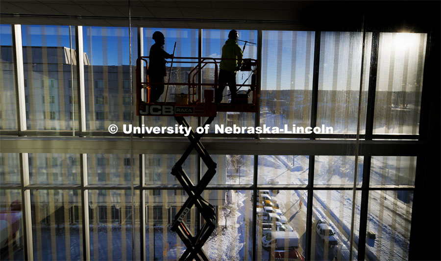 Workers clean the windows in preparation for Kiewit Hall opening Monday, January 22. January 16, 2024. Photo by Craig Chandler / University Communication and Marketing.