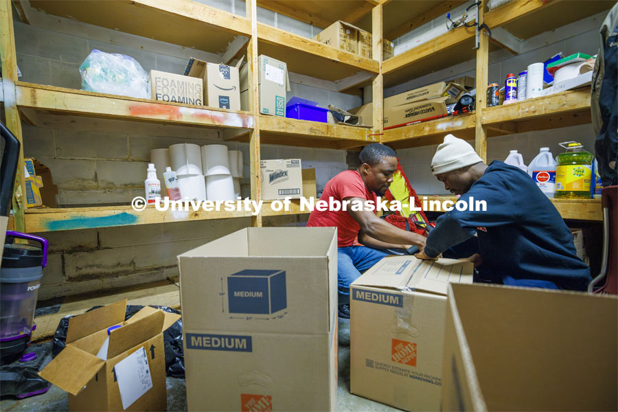Graduate students Nosakhare Idiaghe and Emmanuel Audu pack boxes in a Malone Center storage closet. The center is moving out in the next few weeks to temporary locations while a new center is built on the site. Students volunteer at the Malone Center as part of Martin Luther King Week volunteer opportunities throughout Lincoln. January 23, 2024. Photo by Craig Chandler / University Communication and Marketing.