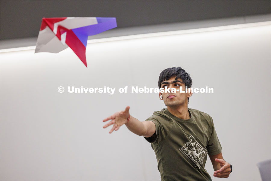 Manas Moondra, a mechanical engineering student, flies a huge paper airplane made by a group of students. The students had 30 minutes to use supplied paper to make their airplanes. Engineering students, staff and faculty finished out the first week of classes in the new Kiewit Hall by having a paper airplane contest in the atrium. Contestants flew three rounds of flights aiming at a bullseye on the first floor. January 26, 2024. Photo by Craig Chandler / University Communication and Marketing.