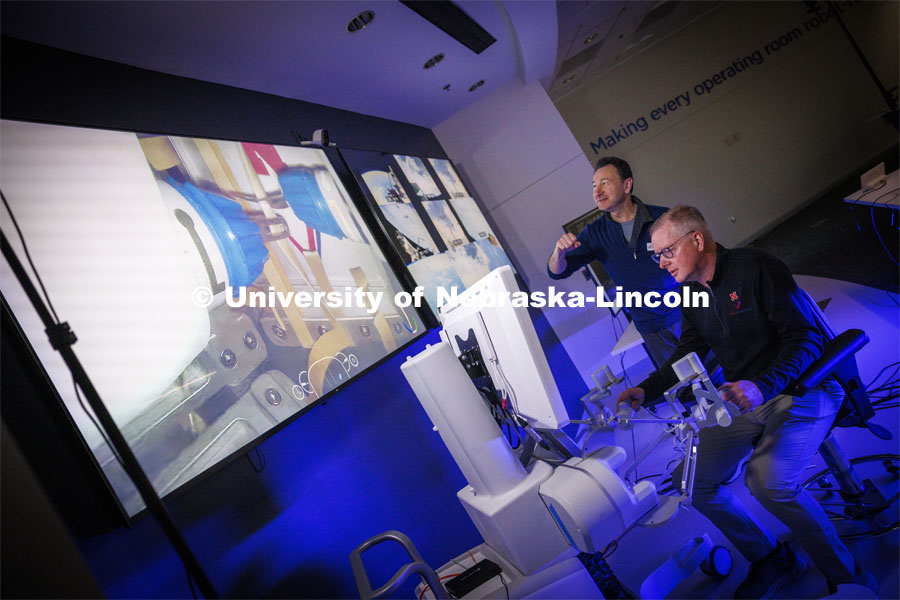 Nebraska Engineering professor and Virtual Incision founder Shane Farritor takes a turn using the surgical robot as Dr. Dmitry Oleynikov mimics the robot’s arm motions. Virtual Incision successfully performed robotic surgery on the International Space Station. Controlled from the Virtual Incision offices in Lincoln, NE, surgeons cut rubber bands–mimicking surgery–inside a payload box on the International Space Station. February 10, 2024. Photo by Craig Chandler / University Communication and Marketing.