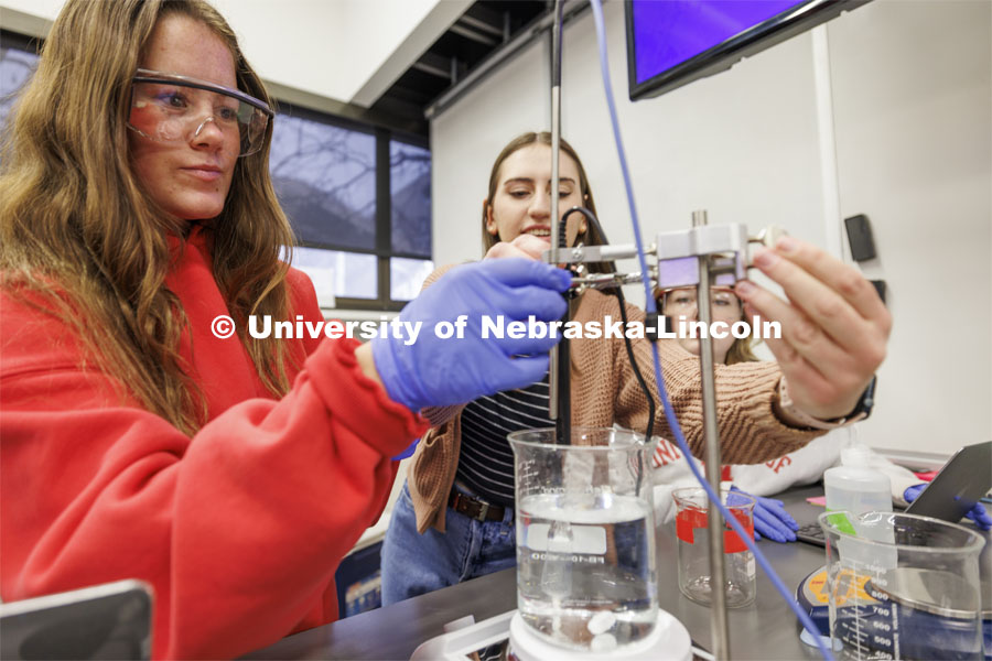 Megan Snyder adjusts the heating and temperature probes in a sample fluid while teaching assistant Lauren Sturgell helps. LIFE 120L - Fundamentals of Biology lab in Manter Hall. February 22, 2024. Photo by Craig Chandler / University Communication and Marketing.