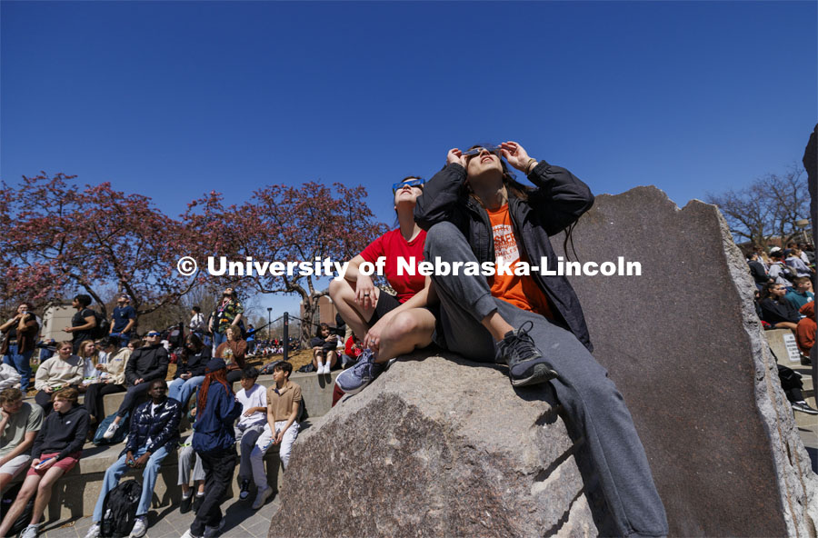 Students view the eclipse from atop of the Broyhill fountain. The Solar Social party to view the partial solar eclipse filled the greenspace outside the Nebraska Union on City Campus. April 8, 2024. Photo by Craig Chandler / University Communication and Marketing.