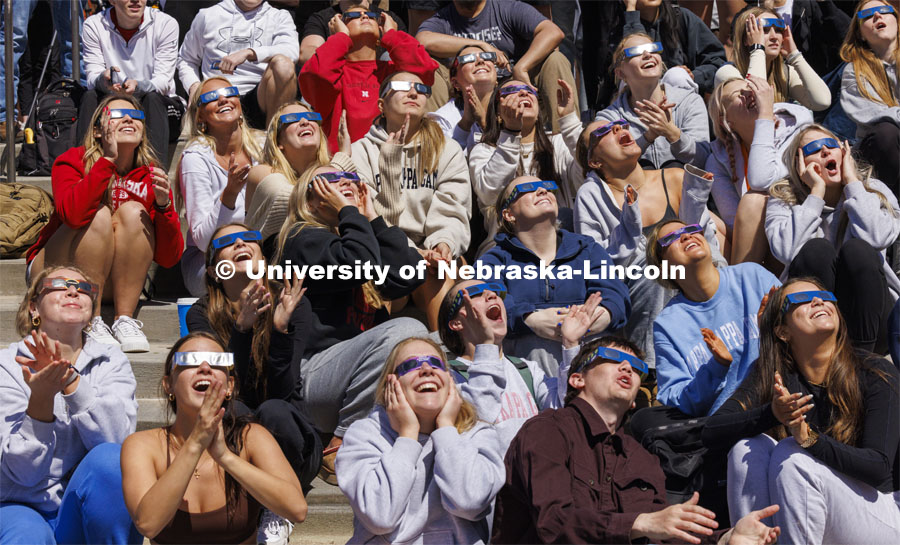 Kappa Kappa Gamma members cheer at 1:53 pm for the highest coverage of the sun. The Solar Social party to view the partial solar eclipse filled the greenspace outside the Nebraska Union on City Campus. April 8, 2024. Photo by Craig Chandler / University Communication and Marketing.
