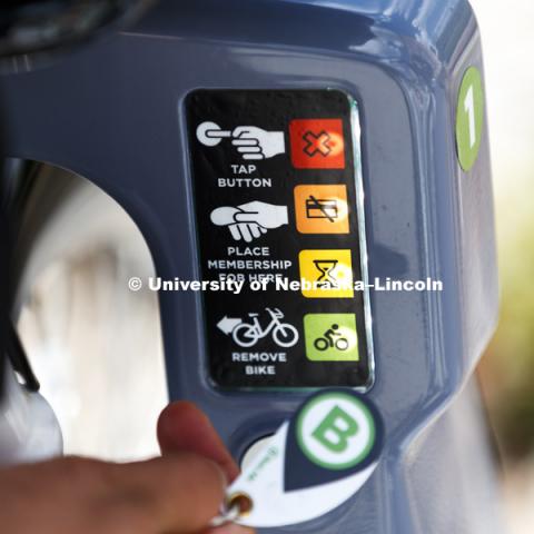 A keyfob unlocks the bicycle from the rack. Achintya Handa uses the BikeLNK system to demonstrate the bicycle on campus. July 31, 2018. Photo by Craig Chandler / University Communication.