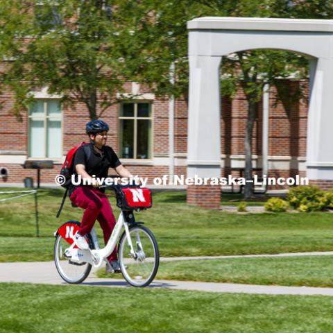 Achintya Handa uses the BikeLNK system to demonstrate the bicycle on campus. July 31, 2018. Photo by Craig Chandler / University Communication.