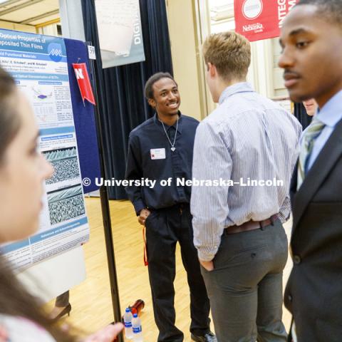 Khalil Bryant, explains his poster entitled "Aspect ratio driven optical properties of glancing angle deposited thin films. Summer Undergraduate Research Fair poster session in the Nebraska Union Ballroom. August 7, 2018. Photo by Craig Chandler /
