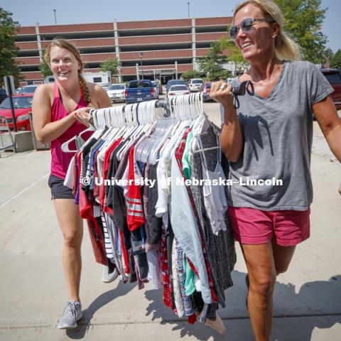 Sidney Therkelsen and her mom, Jodi, carry a rod full of clothes into Smith Hall Sunday afternoon. Housing move in for sorority rush week. August 12, 2018. Photo by Craig Chandler / University Communication.