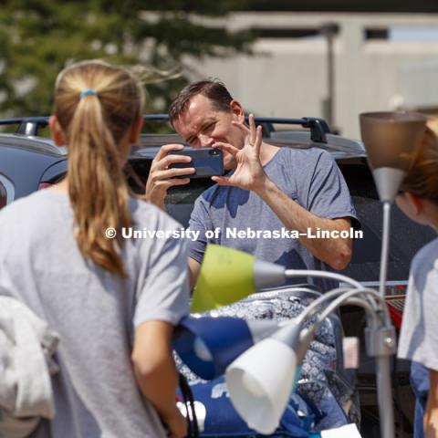 Mike Zimmerman from Liberty, Missouri, takes a photo of daughters including new freshman Emily Zimmerman who was moving into Smith Hall at the start of sorority rush week. August 12, 2018. Photo by Craig Chandler / University Communication.