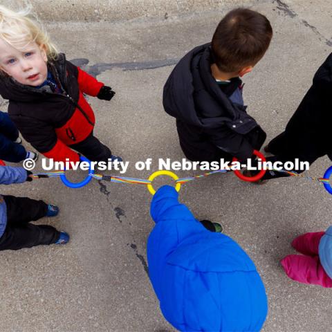 Children hold rings linked together as they walk down the sidewalks on East Campus. Students in the Ruth Staples Child Development Lab go on a field trip to the Nebraska East Union and a walk around campus. March 1, 2024. Photo by Craig Chandler / University Communication and Marketing.