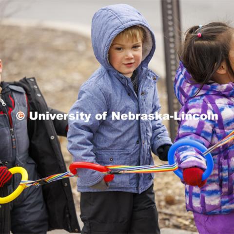 Children hold rings linked together as they walk down the sidewalks on East Campus. Students in the Ruth Staples Child Development Lab go on a field trip to the Nebraska East Union and a walk around campus. March 1, 2024. Photo by Craig Chandler / University Communication and Marketing.