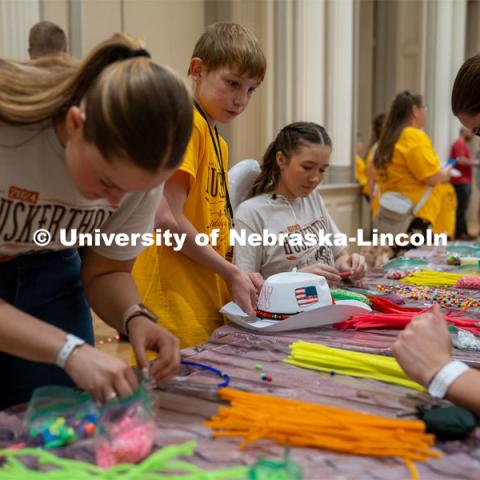 University of Nebraska-Lincoln student, Ava Strunk, helps create decorations for a cowboy hat at Dance Marathon. University of Nebraska–Lincoln students raised $83,702.24 during the annual HuskerThon. Also known as Dance Marathon, the event is part of a nationwide fundraiser supporting Children’s Miracle Network Hospitals. The annual event, which launched in 2006, is the largest student philanthropic event on campus. The mission of the event encourages participants to, “dance for those who can’t.” All funds collected by the Huskers benefit the Children’s Hospital and Medical Center in Omaha. March 2, 2024. Photo by Kirk Rangel.
