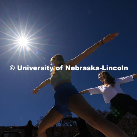 Mekenzie Horihan and Maggie Martin do yoga on the greenspace during the eclipse. The Solar Social party to view the partial solar eclipse filled the greenspace outside the Nebraska Union on City Campus. April 8, 2024. Photo by Craig Chandler / University Communication and Marketing.