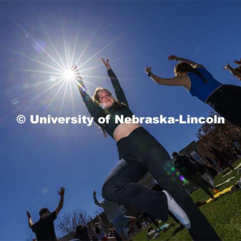 TJ Cass holds the tree pose during yoga on the greenspace during the eclipse. The Solar Social party to view the partial solar eclipse filled the greenspace outside the Nebraska Union on City Campus. April 8, 2024. Photo by Craig Chandler / University Communication and Marketing.