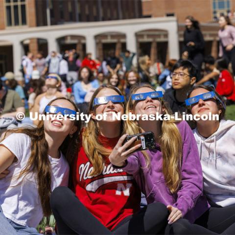 Ava Johnson, Kori Koepper, Christina Schaben and Samantha Pehrson take a selfie of the group watching the eclipse. The Solar Social party to view the partial solar eclipse filled the greenspace outside the Nebraska Union on City Campus. April 8, 2024. Photo by Craig Chandler / University Communication and Marketing.